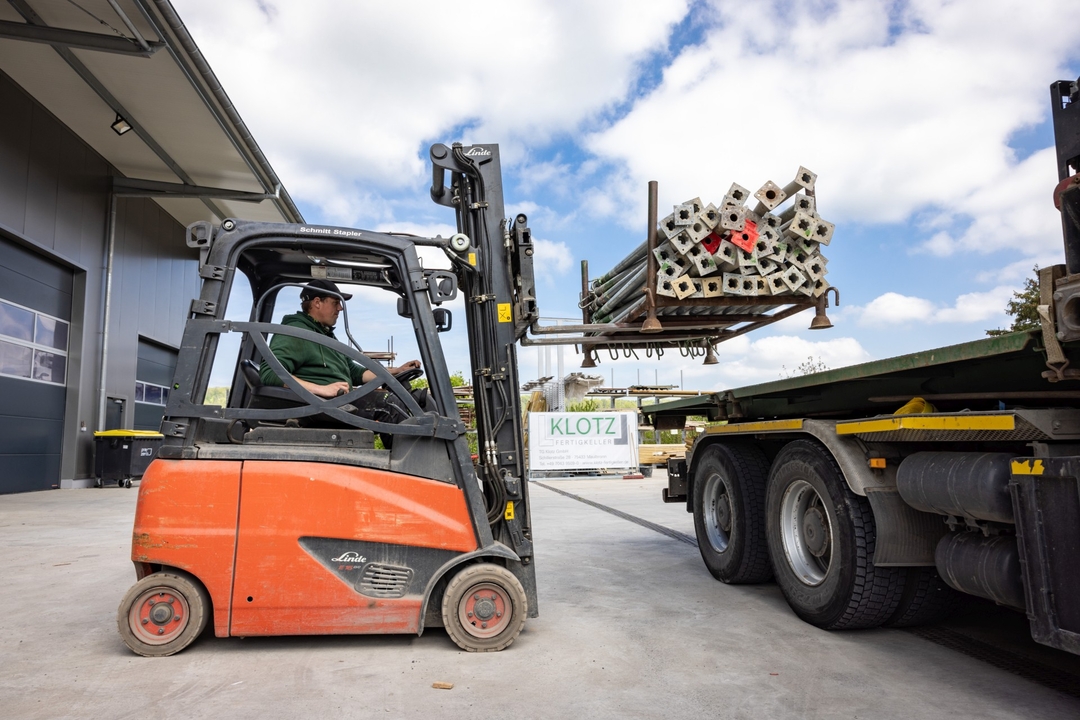 Gabelstapler belädt LKW mit Metallstangen