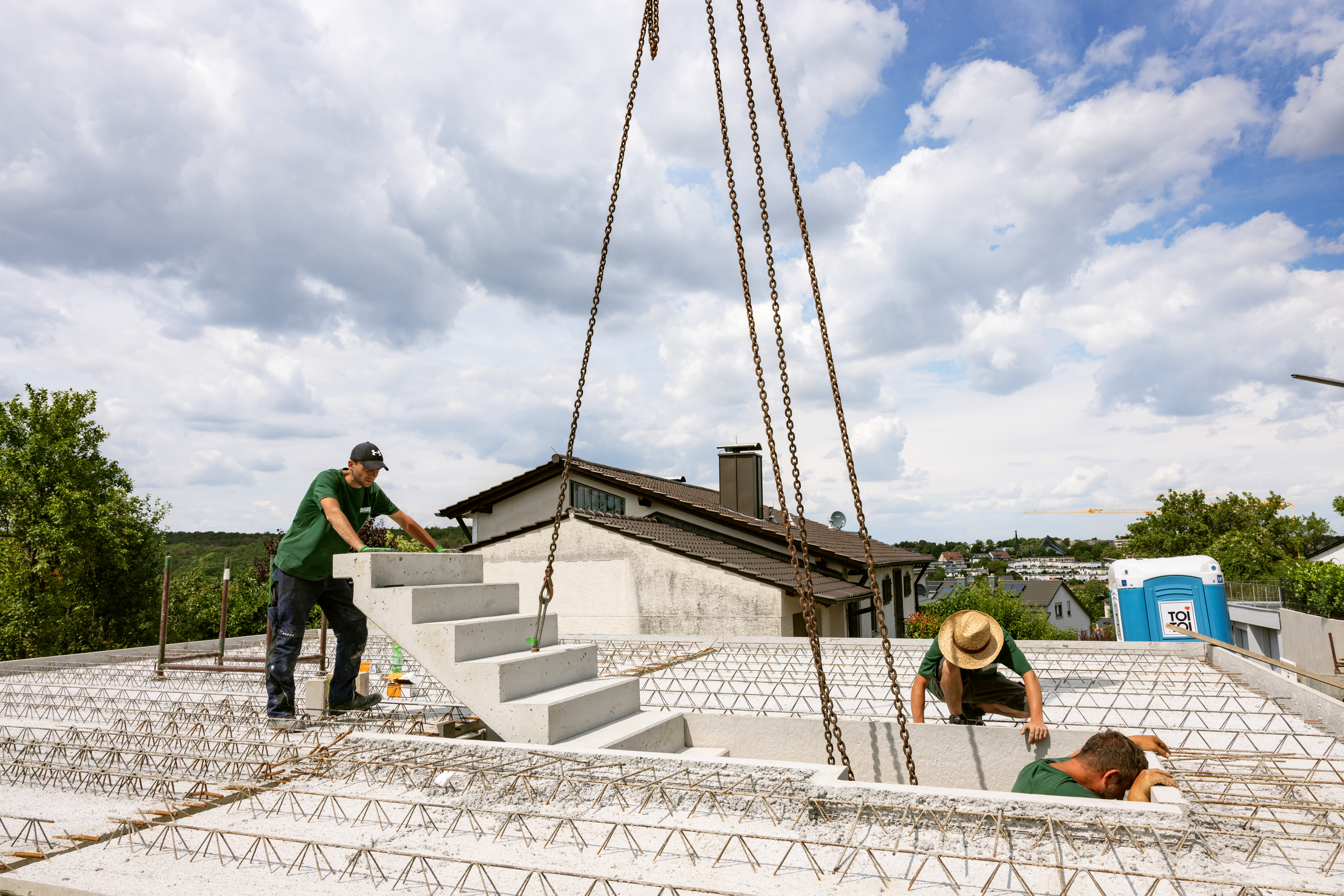 Arbeitsgruppe setzt Betontreppe mit Kran auf Baustelle ein